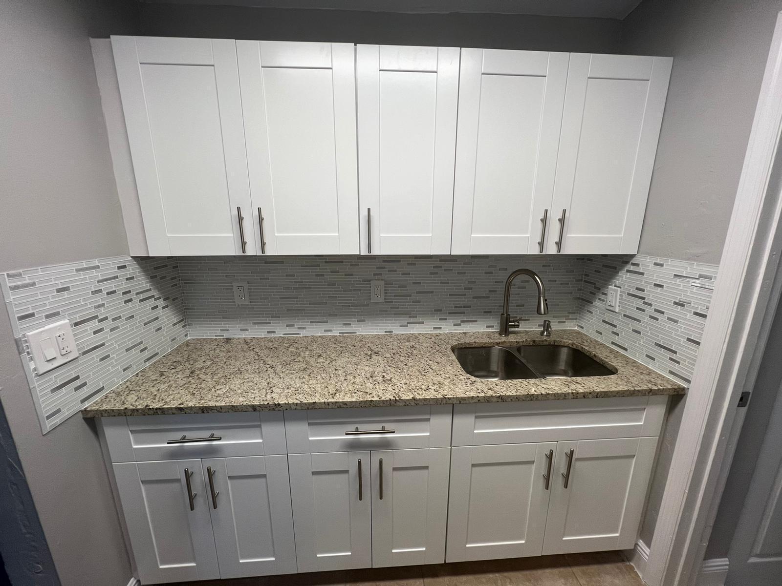 A kitchen kitchenette features white shaker cabinets, granite countertops, a stainless sink, and tiled backsplash — 3265 E Palm Drive, Boynton Beach FL 33435, BOYNTON BEACH, FL