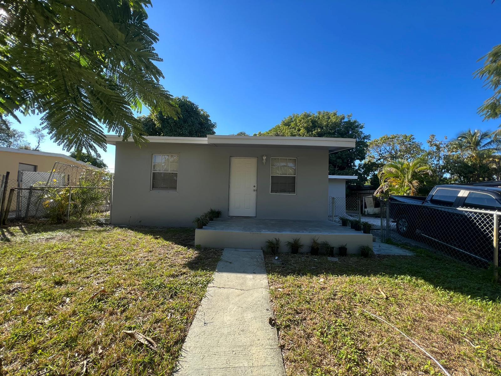 A single-story gray house with a concrete porch and walkway under a clear blue sky — 3265 E Palm Drive, Boynton Beach FL 33435, BOYNTON BEACH, FL