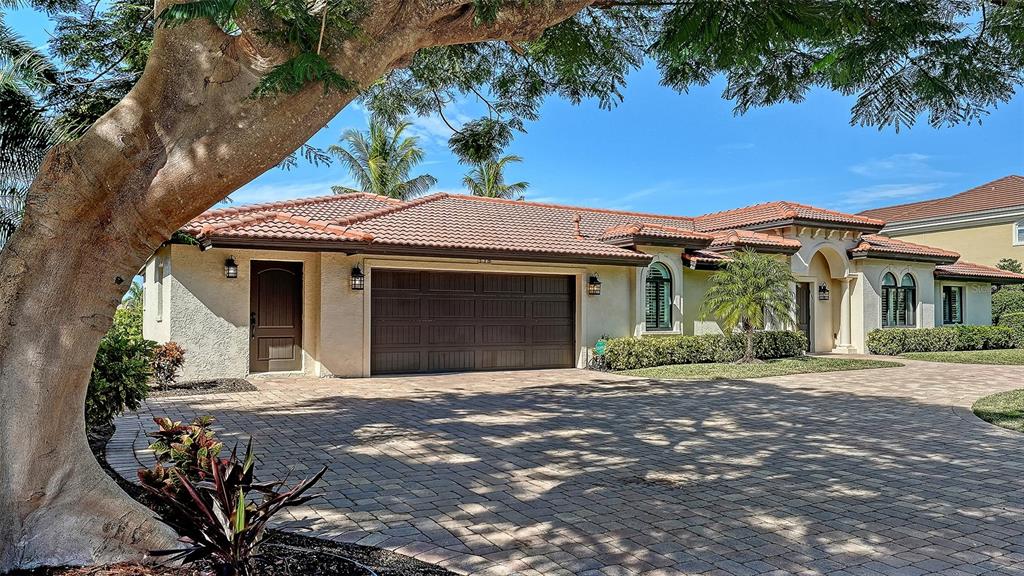 A single-story house with a tiled roof, a multi-car garage, and a paved driveway — 595 BOWSPRIT LANE, LONGBOAT KEY, FL