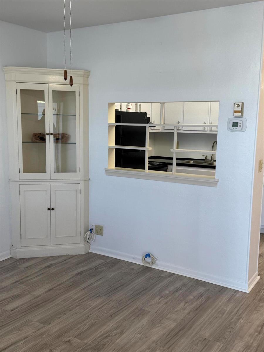 A dining area features a corner hutch, a kitchen pass-through window, and light wood-look flooring — 2960 Lake Osborne Drive # 209, FL 33461, FL