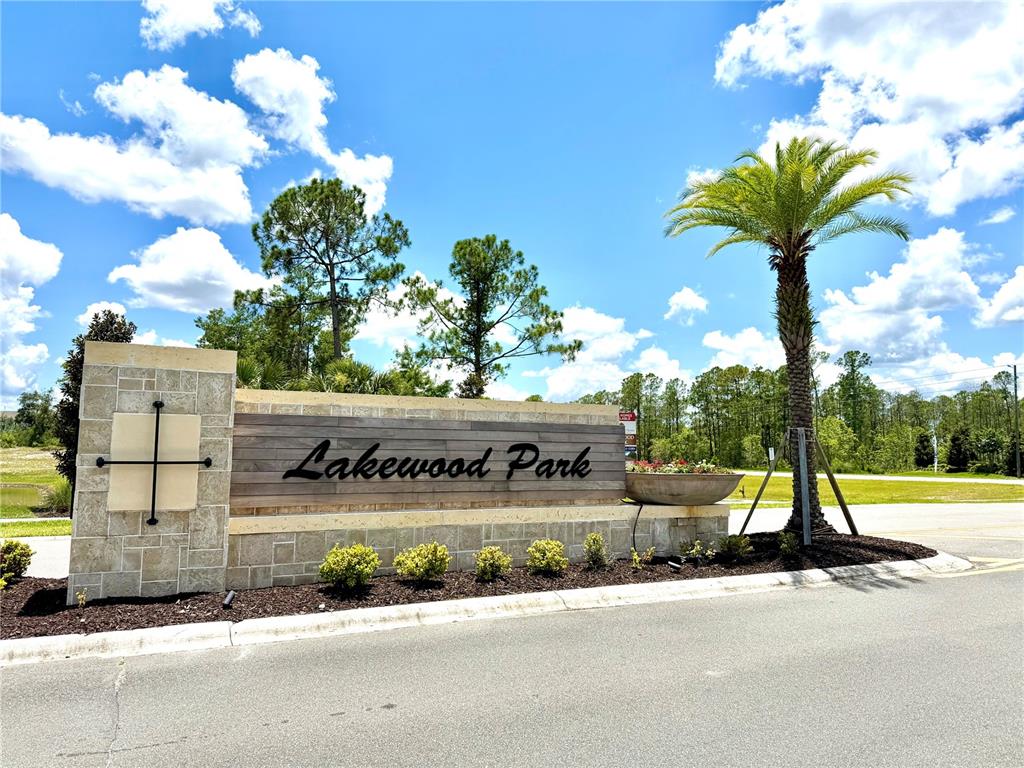 A stone and wood monument sign for Lakewood Park stands beside a palm tree — 9136 CAPE COD ROAD, DELAND, FL