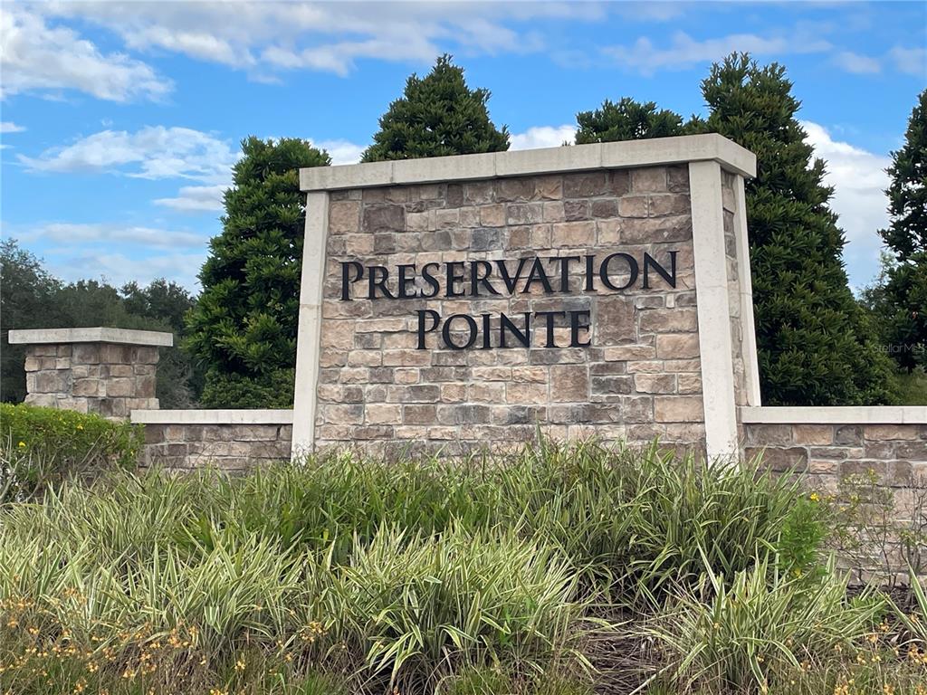 A stone monument sign for Preservation Pointe stands behind a patch of green landscaping — 1437 SAWGRASS HAMMOCK LANE, DAVENPORT, FL