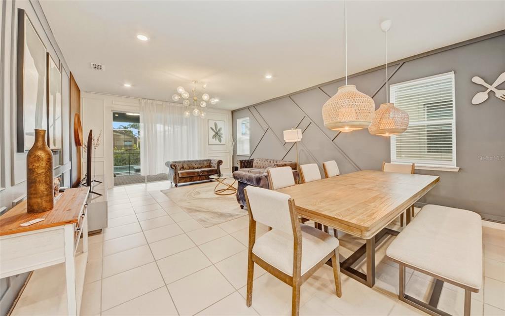 A dining area with a wooden table and chairs sits adjacent to a living room — 4063 LANA AVENUE, DAVENPORT, FL