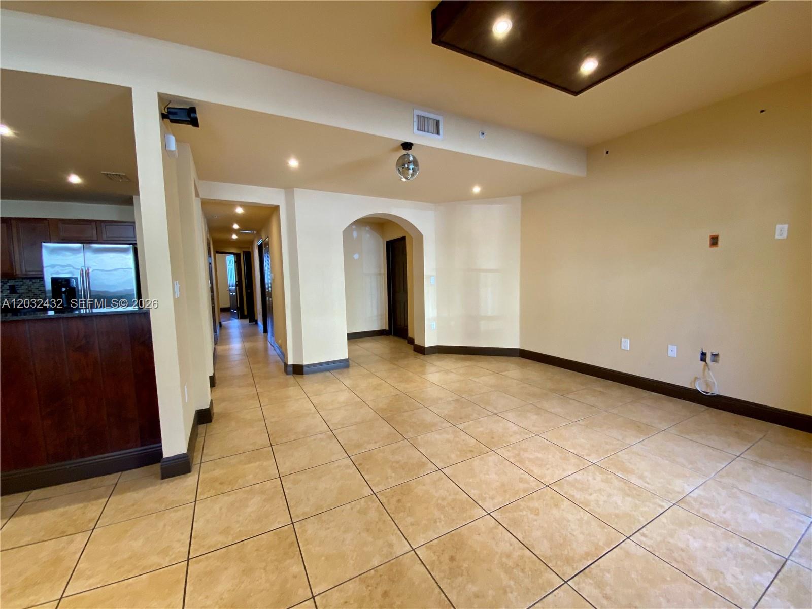 An interior view shows a tiled living area with an arched doorway and a disco ball — 8800 NW 107th CT # 110, Doral FL 33178, DORAL, FL