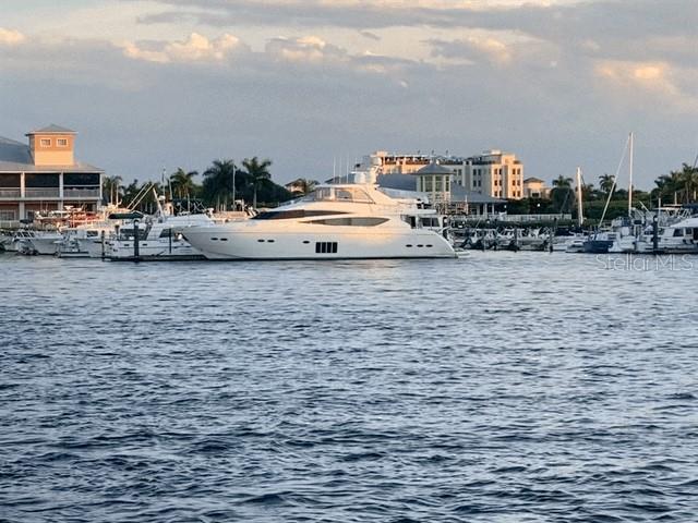 A large white yacht is docked in a marina near buildings under a cloudy sky — 411 SOLONA STREET, PUNTA GORDA, FL