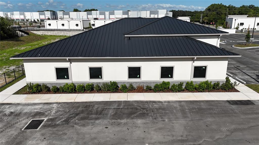 An exterior view of a modern single-story commercial building with a black metal roof — 2745 OCOEE APOPKA ROAD UNIT 10, APOPKA, FL