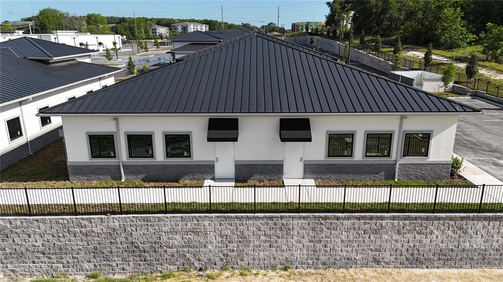An exterior view of a modern, single-story commercial building with a black metal roof — 2745 OCOEE APOPKA ROAD UNIT 10, APOPKA, FL