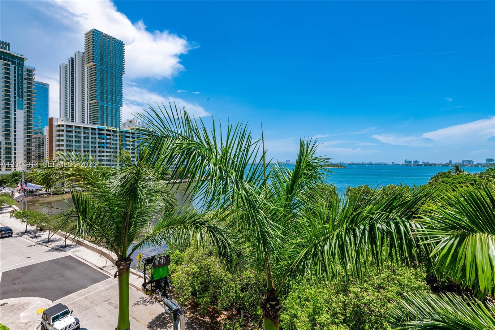 An elevated view of a coastal city skyline, palm trees, and a blue bay — 2000 N Bayshore Dr # 516, Miami FL 33137, MIAMI, FL