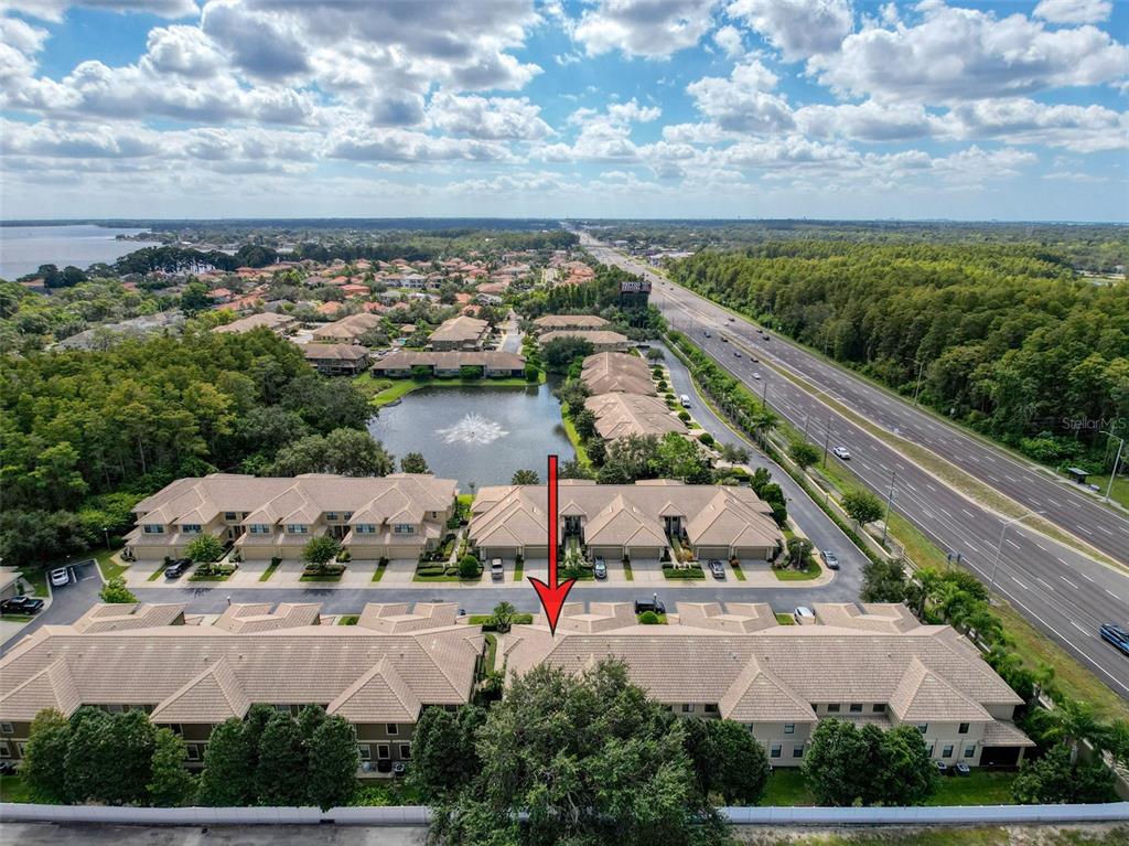 An aerial view of a residential townhouse complex with a red arrow pointing downward — 2539 SILVERBACK COURT, PALM HARBOR, FL