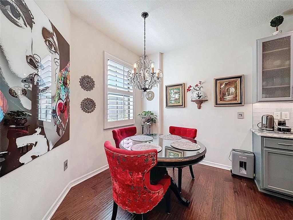 A dining area features a round glass table, red velvet chairs, and a crystal chandelier — 2539 SILVERBACK COURT, PALM HARBOR, FL