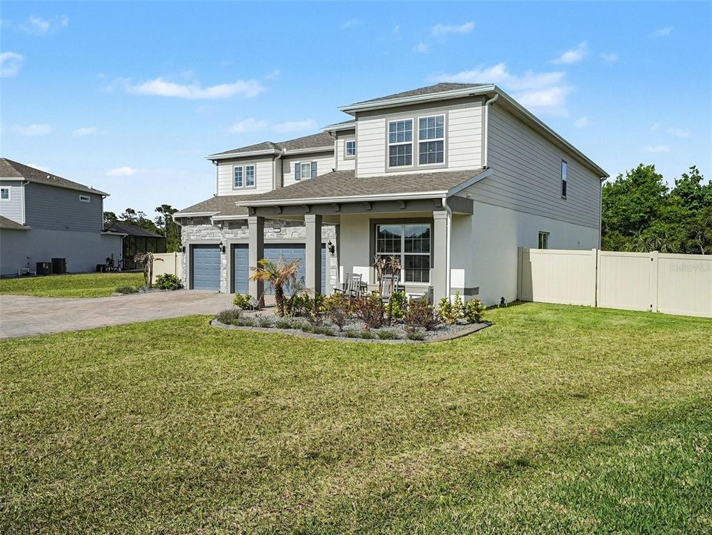 A two-story suburban house with a stone and siding exterior and a covered front porch — 4389 SUNSET PRESERVE BOULEVARD, ORLANDO, FL