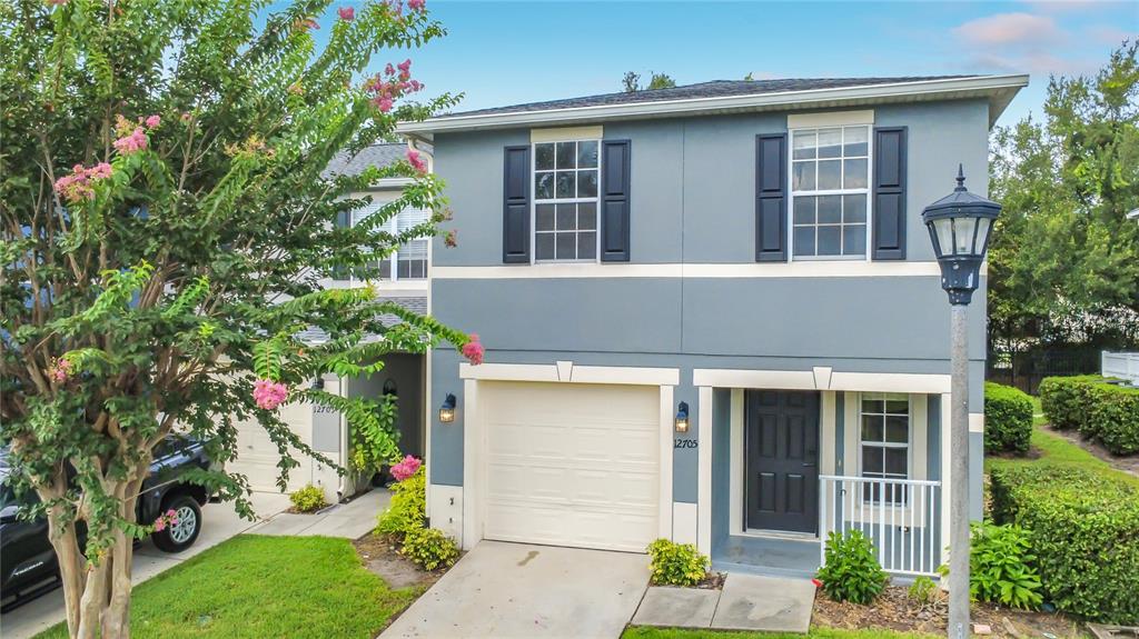 A two-story house with a gray exterior, a single-car garage, and a front entry porch — 12705 LEXINGTON SUMMIT STREET, ORLANDO, FL