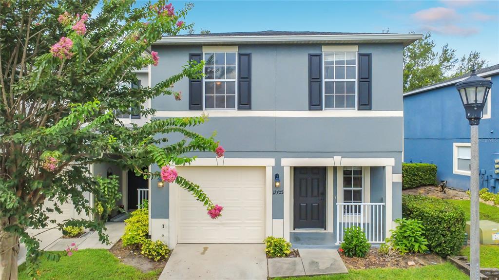 A two-story house with a gray exterior, a single-car garage, and a small front porch — 12705 LEXINGTON SUMMIT STREET, ORLANDO, FL