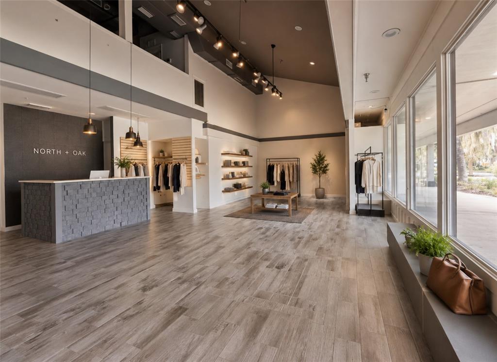 A retail boutique features a stone-front reception desk, wood-look tile flooring, and clothing displays — 2441 NW 43RD STREET UNIT 25A, GAINESVILLE, FL