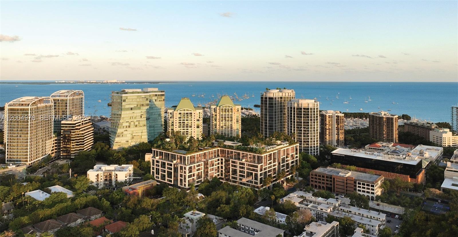 An aerial view shows a dense cluster of modern high-rise buildings near a coastal bay — 2835 S Tigertail Ave # 7, Coconut Grove FL 33133, COCONUT GROVE, FL
