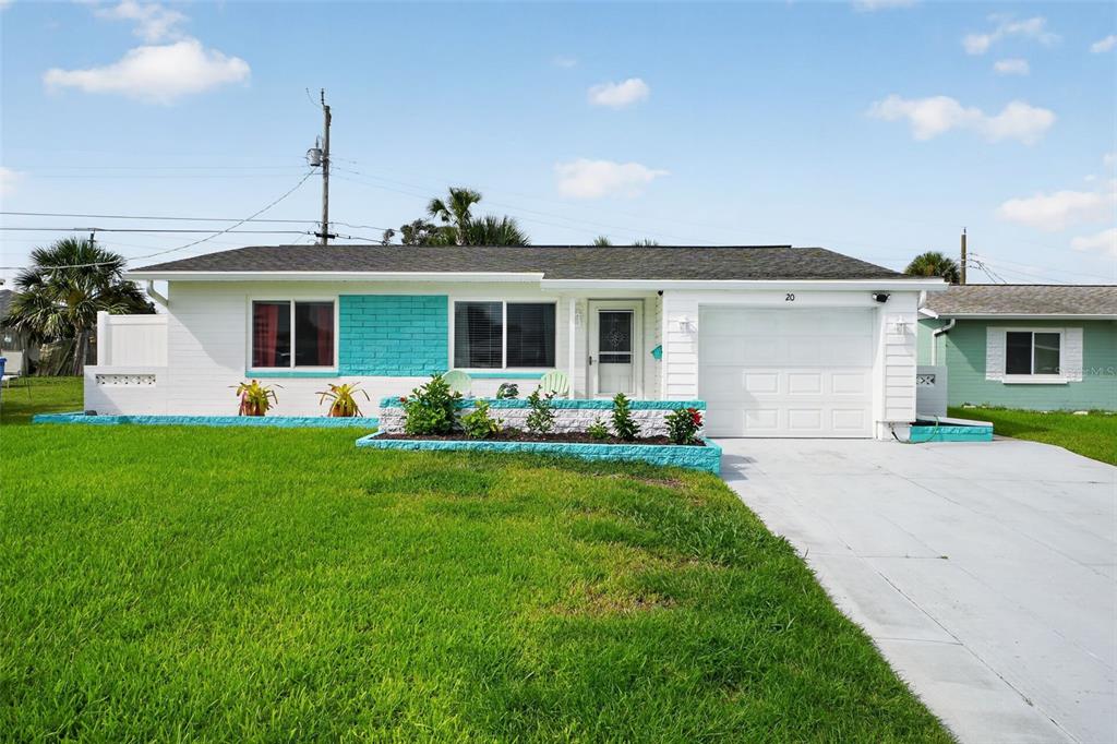 A single-story white house with turquoise accents, a front lawn, and a concrete driveway — 20 SUNNY SHORE DRIVE, ORMOND BEACH, FL