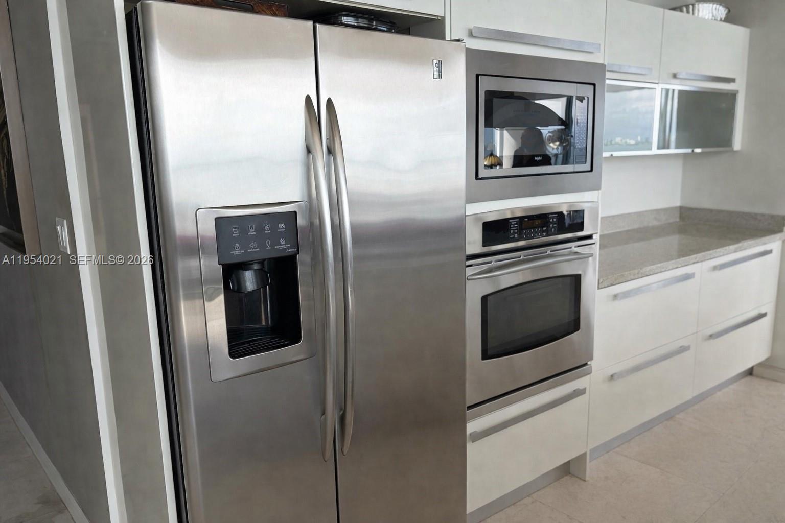 A modern kitchen features stainless steel appliances, including a refrigerator, wall oven, and microwave — 601 NE 36th St # 1112, Miami FL 33137, MIAMI, FL