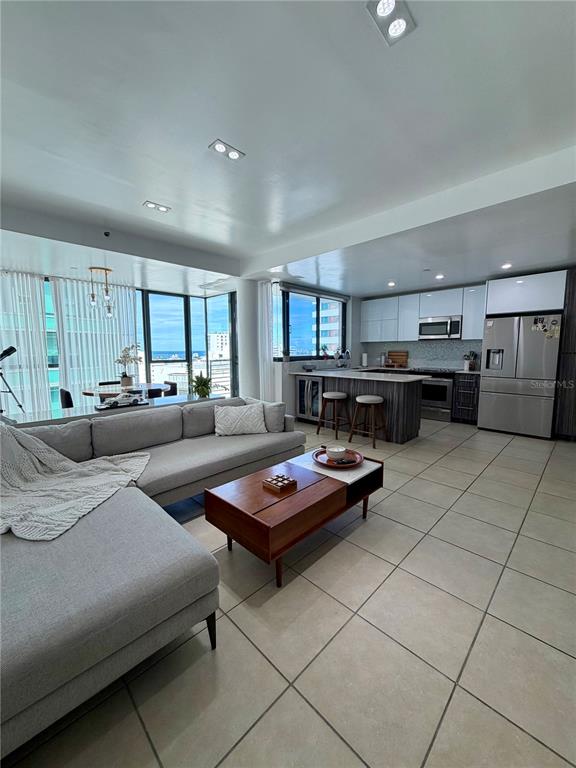 A modern open-concept living room and kitchen feature light tile floors and floor-to-ceiling windows — 1511 PONCE DE LEON AVE UNIT 7, SAN JUAN, PR