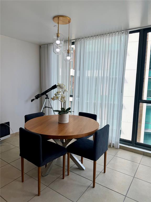 A dining area features a round wooden table, four dark chairs, and a hanging light — 1511 PONCE DE LEON AVE UNIT 7, SAN JUAN, PR
