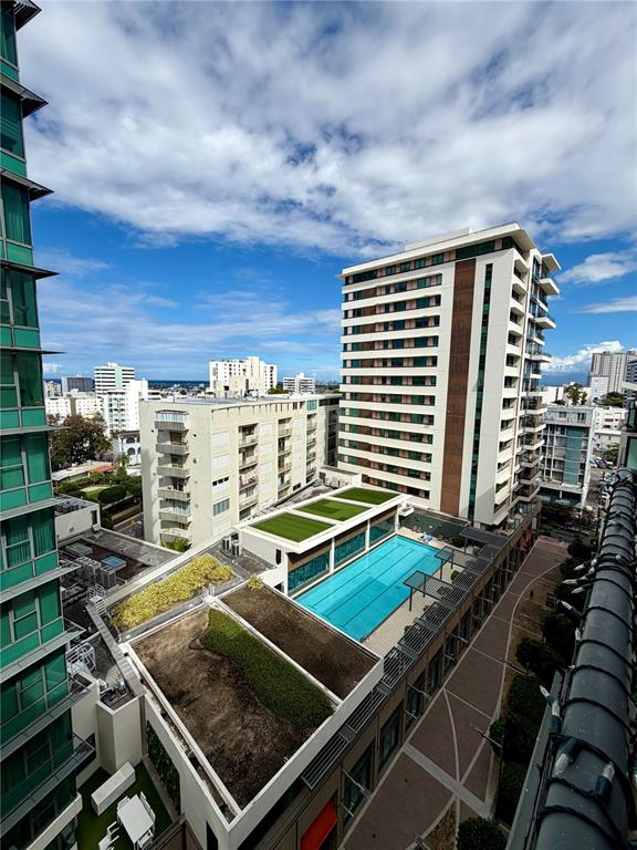 An elevated view shows a swimming pool and green roof between two tall apartment buildings — 1511 PONCE DE LEON AVE UNIT 7, SAN JUAN, PR