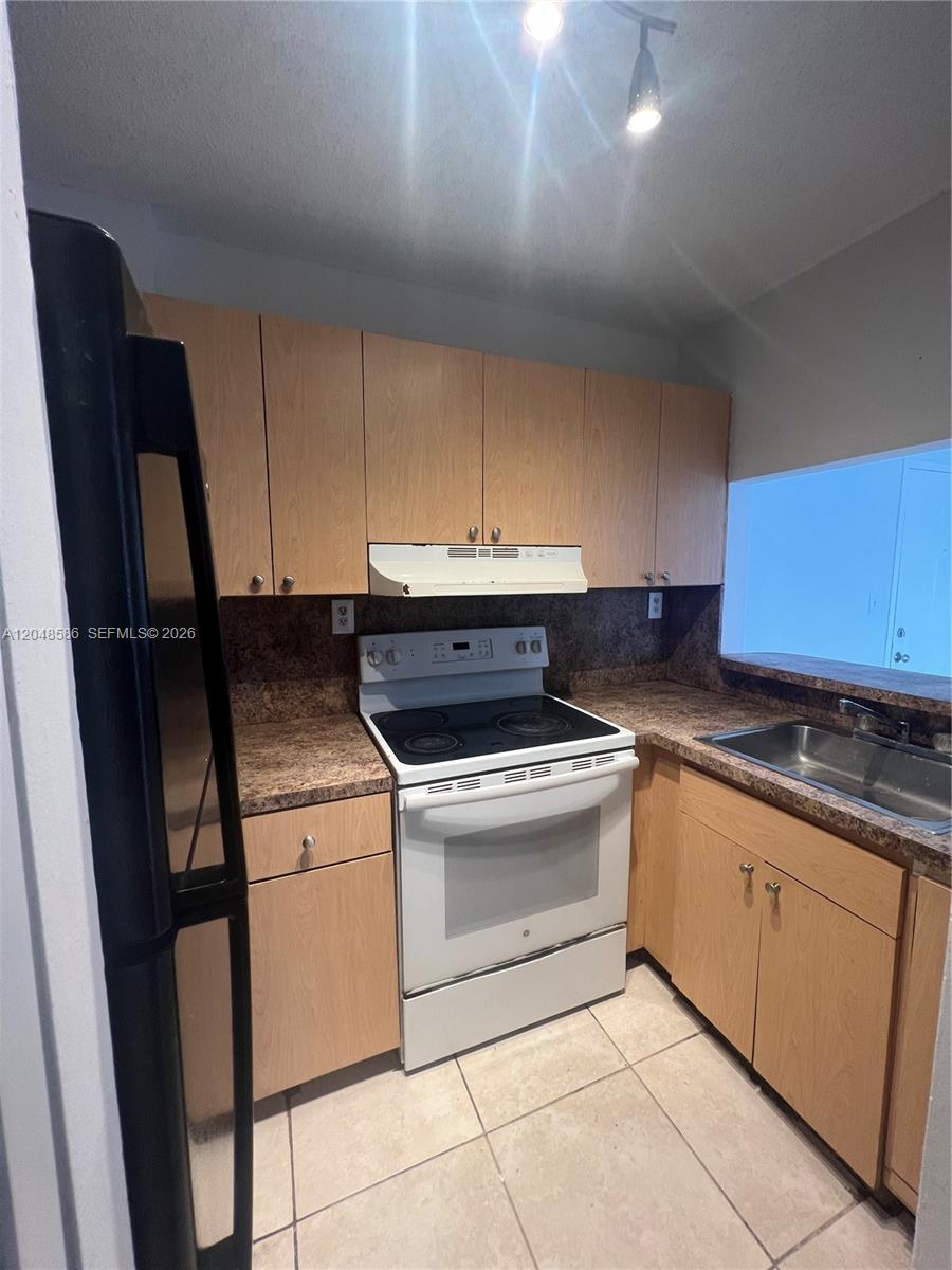 A kitchen features light wood cabinets, brown laminate countertops, and white appliances — 8145 NW 7th St # 405, Miami FL 33126, MIAMI, FL