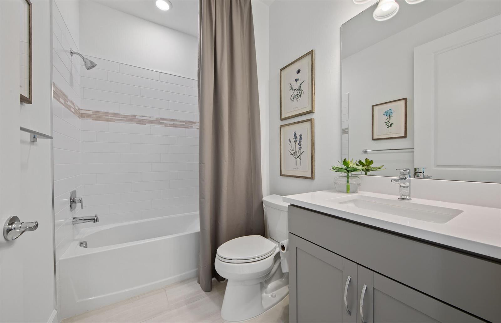 A bathroom features a gray vanity, a white toilet, and a shower-tub combo with tile — 3968 Sweet Alyssum Terrace, FL 33920, FL