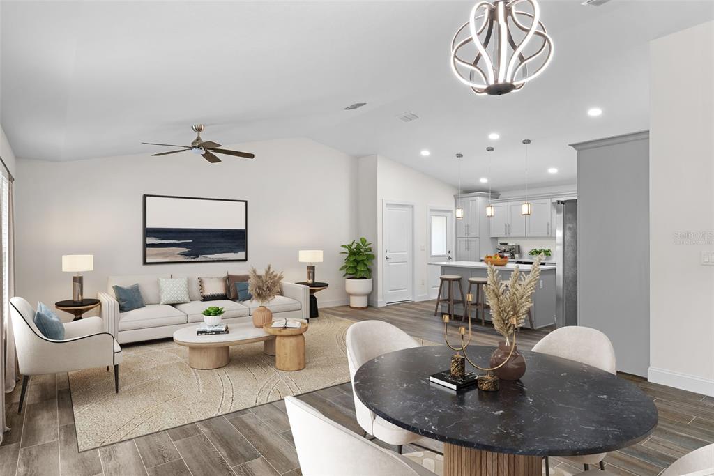 An open-concept living room and kitchen area with a dining table in the foreground — 5160 80TH WAY N, ST PETERSBURG, FL