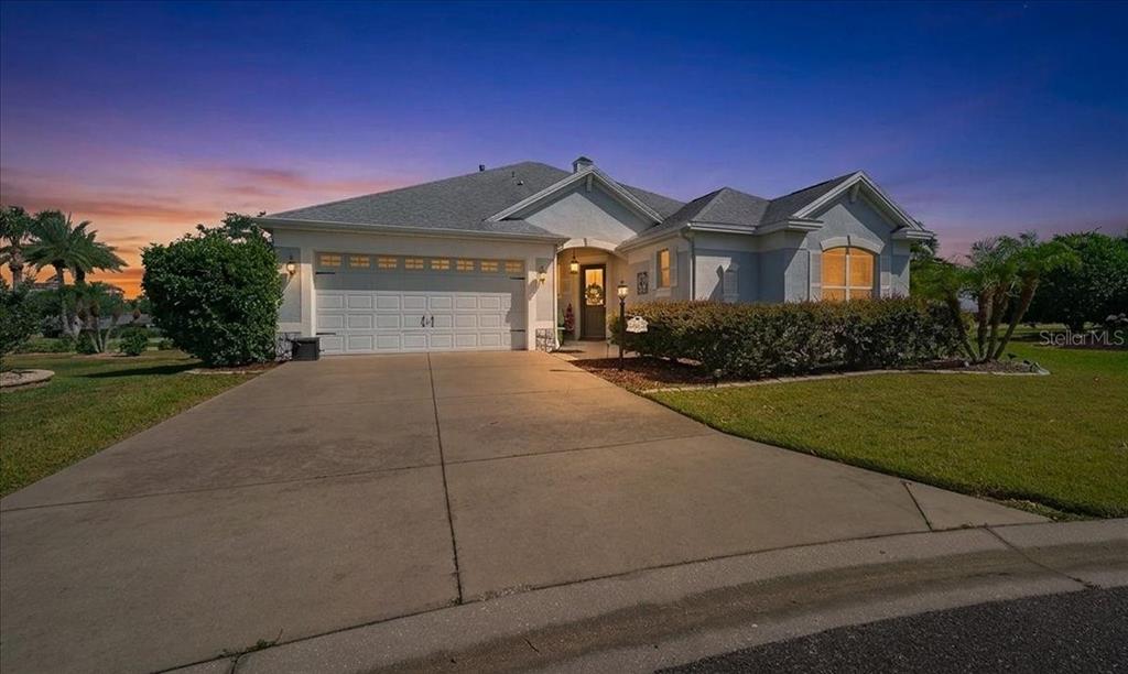 A single-story suburban house with a two-car garage, concrete driveway, and landscaped front yard — 1606 SNELLING AVENUE, THE VILLAGES, FL