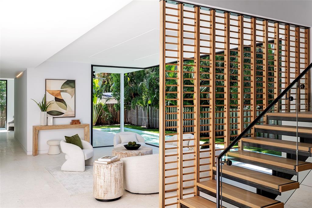 A modern house exterior features a wood-paneled garage, stone walls, and a flat roof — 1642 BAHIA VISTA STREET, SARASOTA, FL