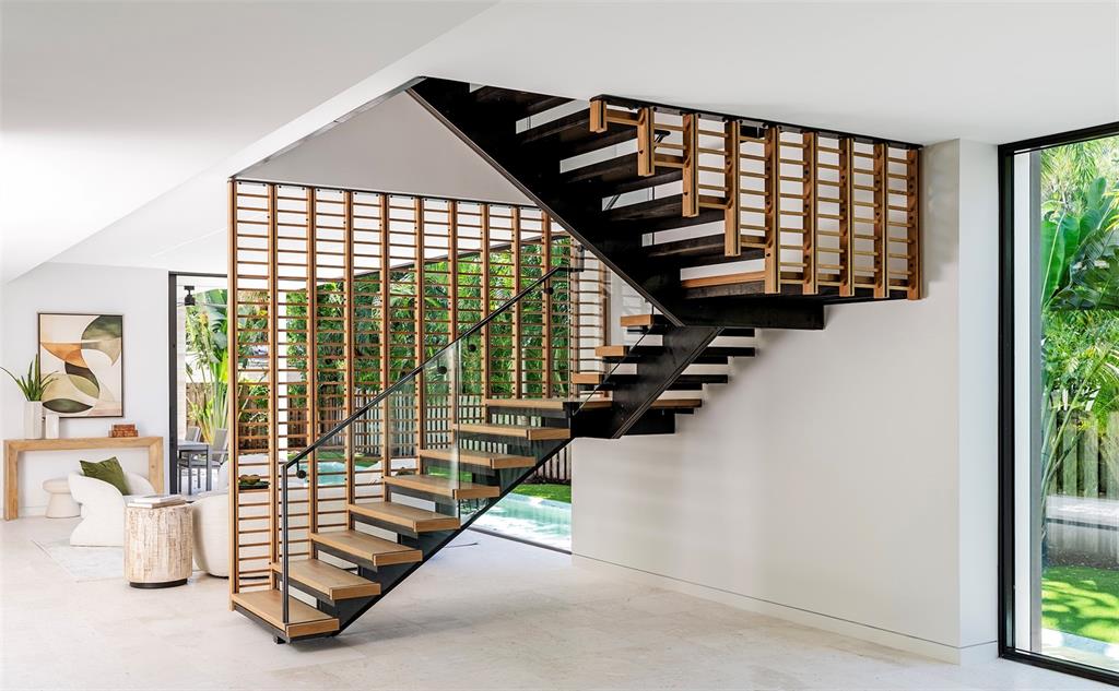 A modern house exterior features a stone facade, a covered entryway, and lush landscaping — 1642 BAHIA VISTA STREET, SARASOTA, FL