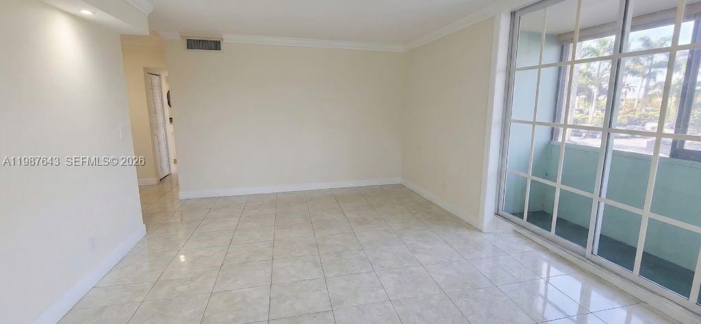An empty room features light-colored tile flooring, white walls, and a large grid-paned window — 5055 NW 7th St # 206, Miami FL 33126, MIAMI, FL