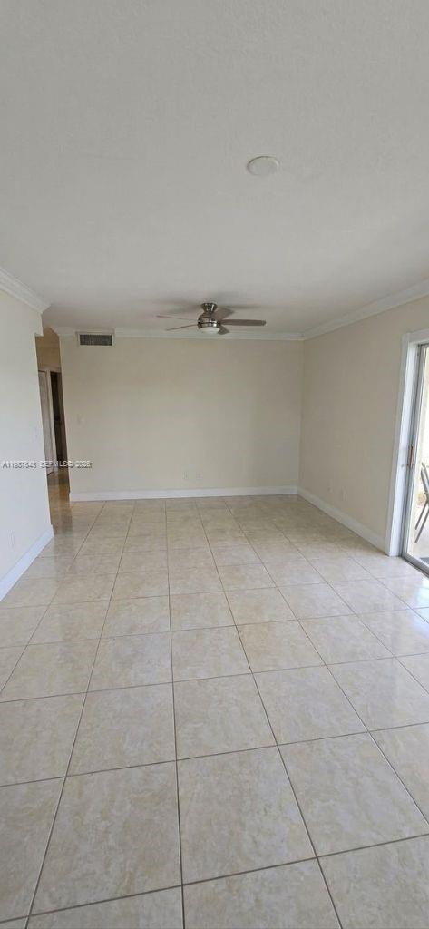 An empty room features light-colored tile flooring, a ceiling fan, and a sliding glass door — 5055 NW 7th St # 206, Miami FL 33126, MIAMI, FL
