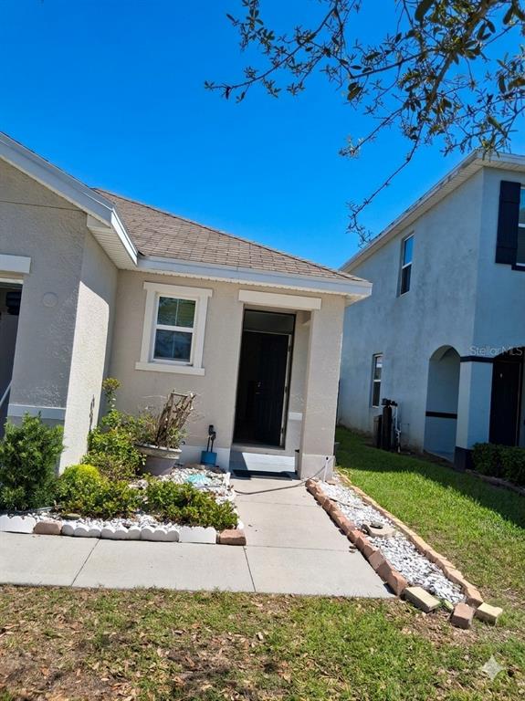 A tan house exterior features a front entrance, a small garden bed, and a walkway — 6656 SEAWAY DRIVE, BROOKSVILLE, FL