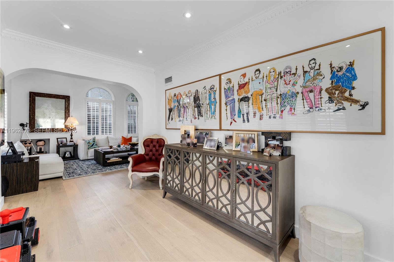 A living room features light wood floors, a mirrored sideboard, and large framed figure drawings — 1826 Fairhaven Pl, Miami FL 33133, MIAMI, FL