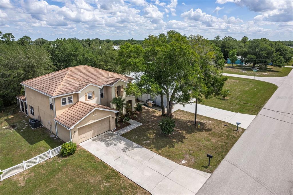 An aerial view shows a two-story tan house with a tiled roof and concrete driveway — 545 ENCARNACION STREET, PUNTA GORDA, FL