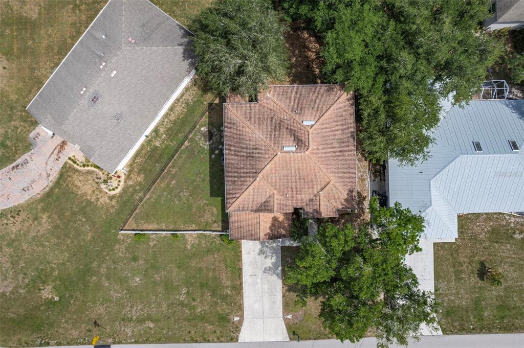 An aerial view shows a house with a brown tile roof between two neighboring homes — 545 ENCARNACION STREET, PUNTA GORDA, FL