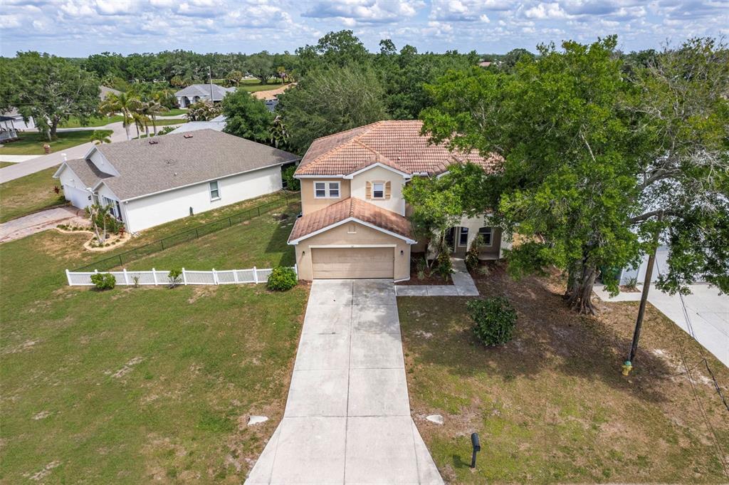 An aerial view shows a two-story house with a tile roof, driveway, and large tree — 545 ENCARNACION STREET, PUNTA GORDA, FL