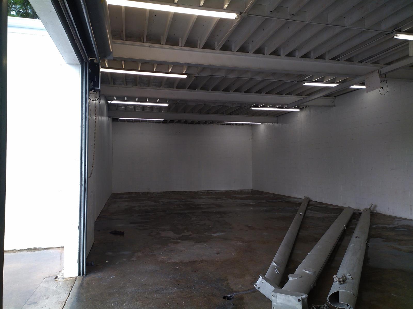 An empty warehouse space with white block walls, exposed ceiling beams, and concrete flooring — 3625 Metzger Road, Fort Pierce FL 34947, FORT PIERCE, FL