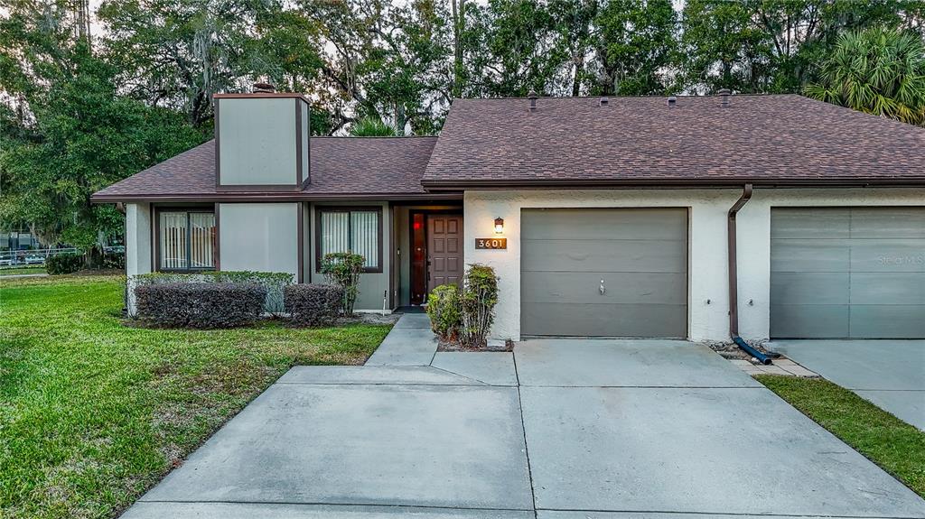 A single-story duplex with a brown shingled roof, stucco exterior, and two attached garages — 3601 NE 17TH LANE, OCALA, FL