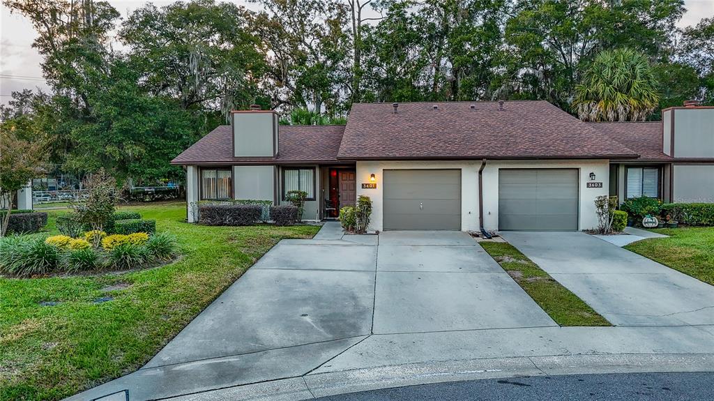 A single-story duplex with two garage doors and a shared concrete driveway — 3601 NE 17TH LANE, OCALA, FL