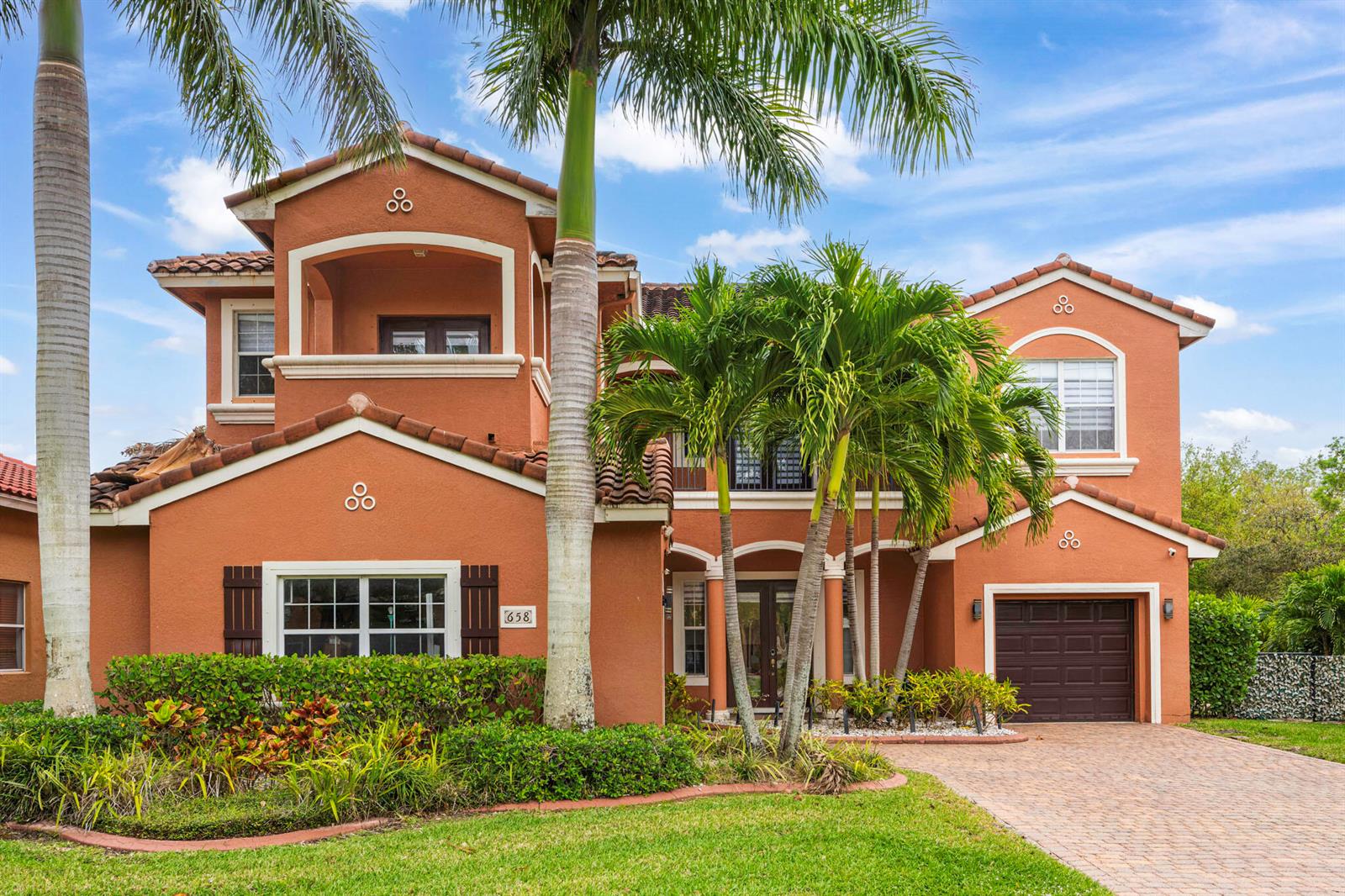 A two-story stucco house with a tile roof, palm trees, and a paved driveway — 658 Cresta Circle, West Palm Beach FL 33413, WEST PALM BEACH, FL