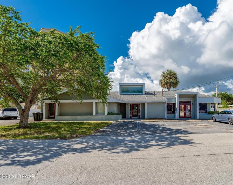 A single-story commercial building with a gray exterior, red doors, and a large tree — 2763 S RIDGEWOOD AVENUE, SOUTH DAYTONA, FL