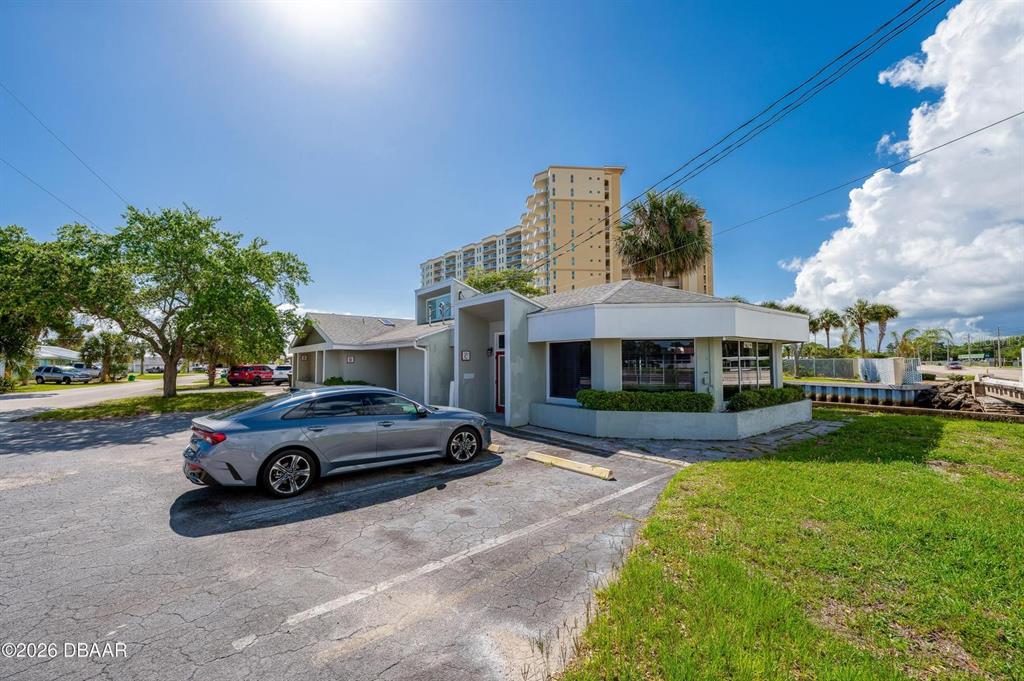 A gray sedan is parked in front of a single-story commercial building with large windows — 2763 S RIDGEWOOD AVENUE, SOUTH DAYTONA, FL