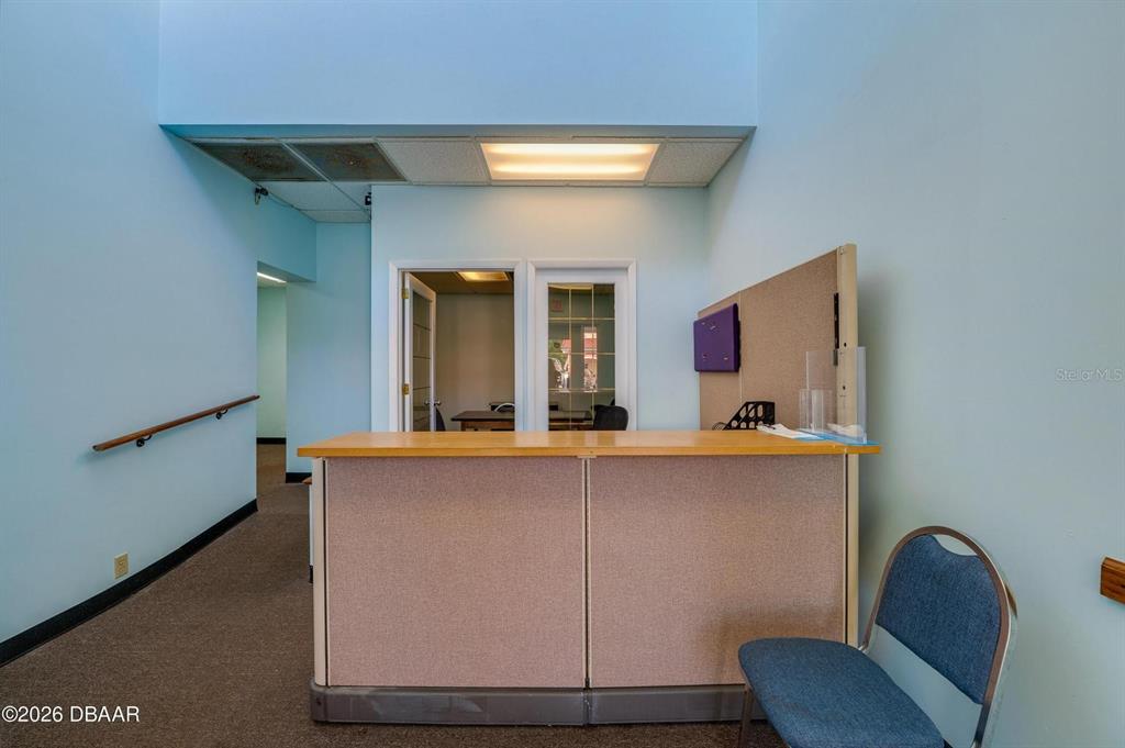 A reception area features a light-colored desk, blue walls, and a carpeted floor — 2763 S RIDGEWOOD AVENUE, SOUTH DAYTONA, FL