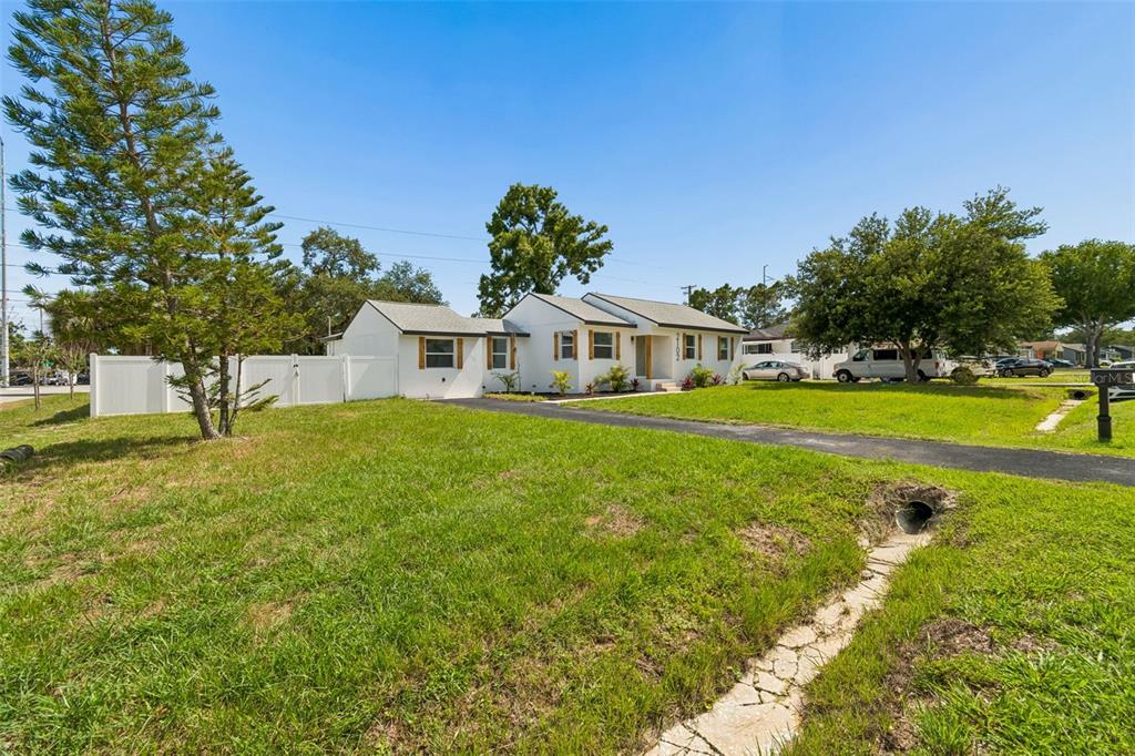 A white single-story house with a long driveway sits on a grassy lot — 2102 W FERRIS AVENUE, TAMPA, FL