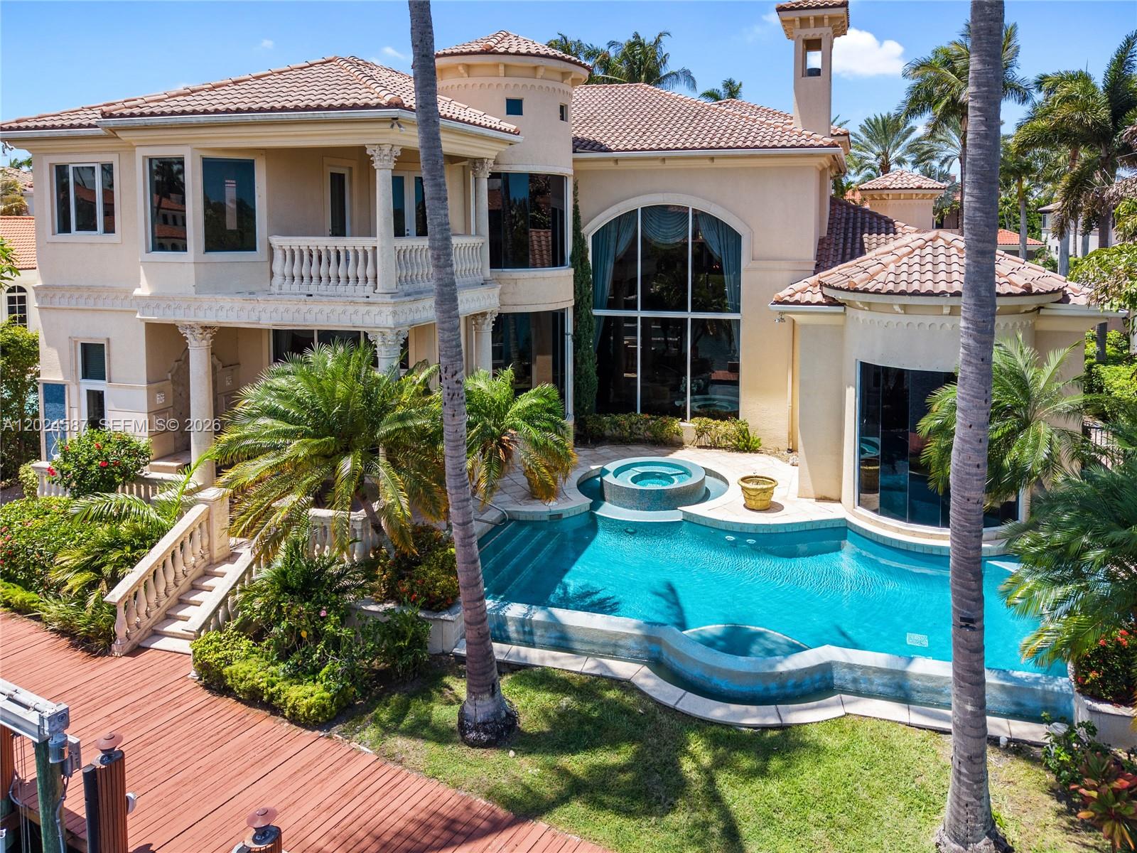 A two-story Mediterranean-style house features a swimming pool, spa, and a wooden deck — 832 Harbour Isle Place, North Palm Beach FL 33410, NORTH PALM BEACH, FL
