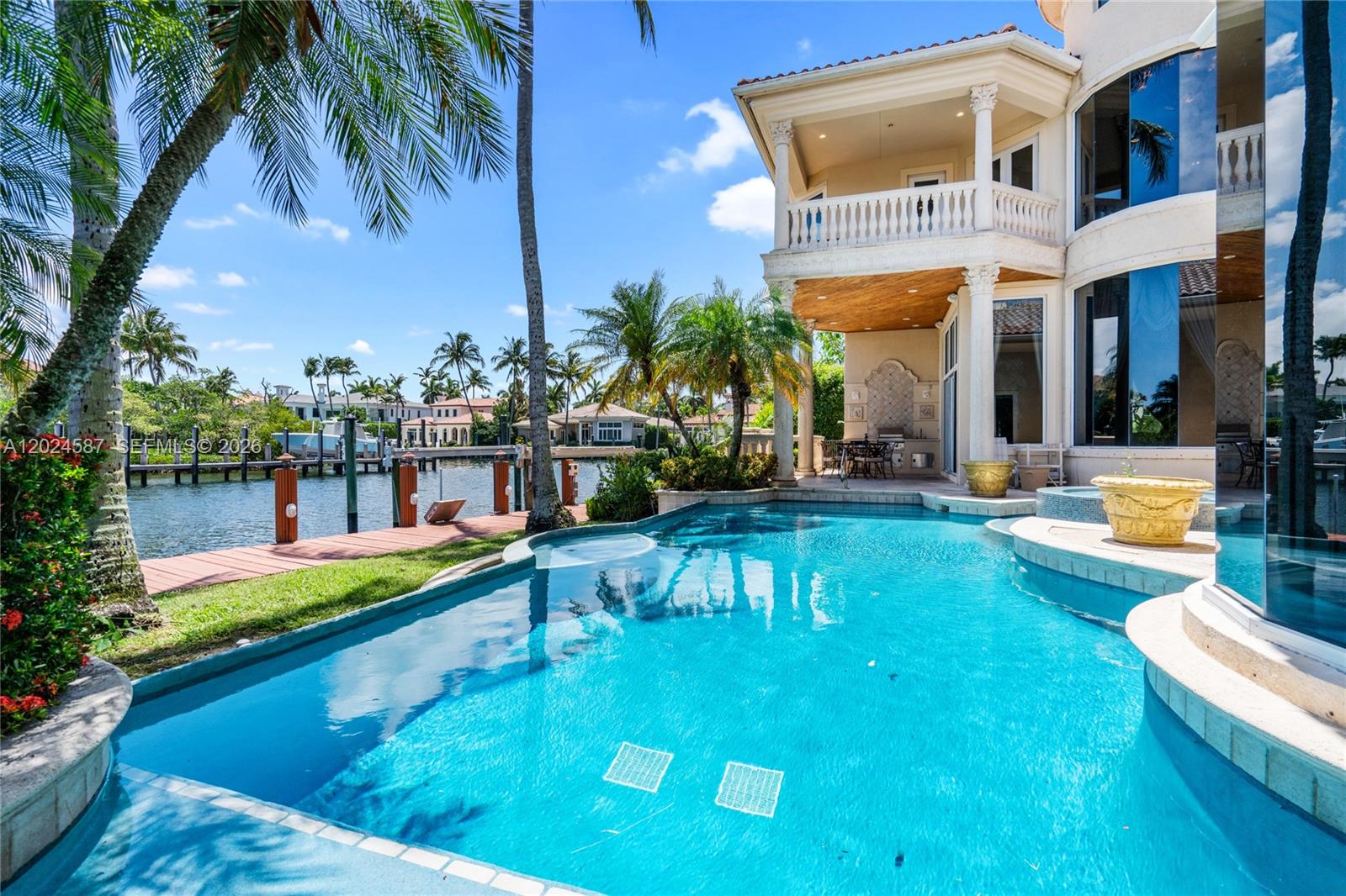 A swimming pool sits beside a waterfront home with a covered patio and boat dock — 832 Harbour Isle Place, North Palm Beach FL 33410, NORTH PALM BEACH, FL