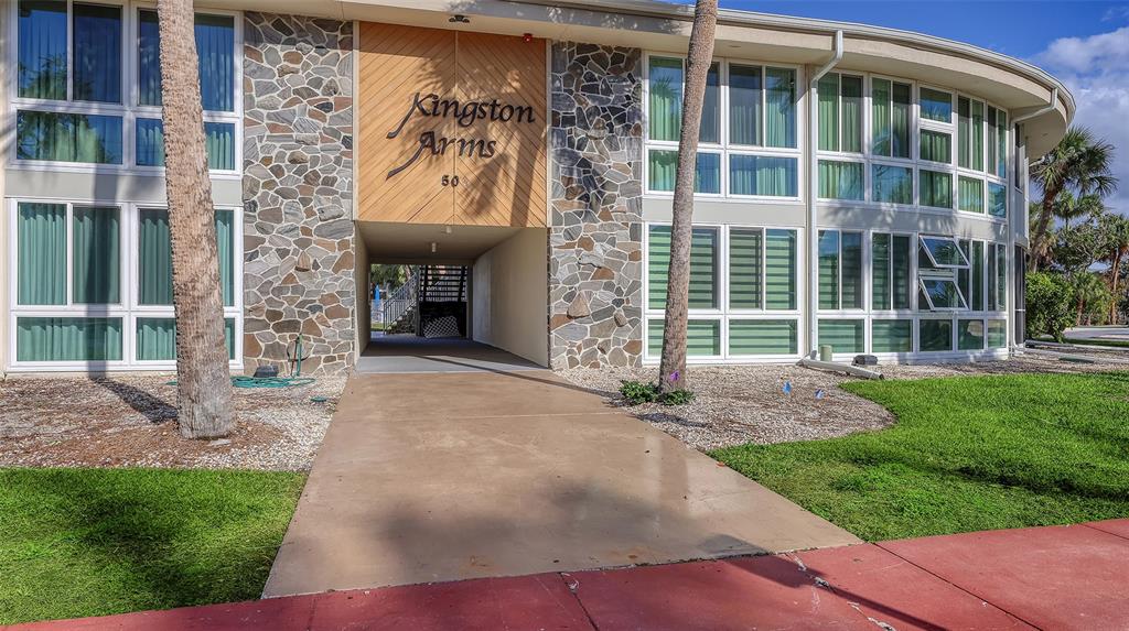 The exterior of a multi-story apartment building features stone accents and a central covered walkway — 500 S WASHINGTON DRIVE UNIT 6A, SARASOTA, FL