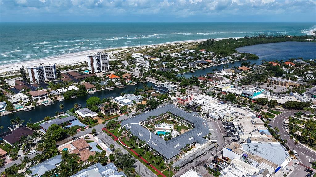 An aerial view shows a coastal town with a large U-shaped building circled in white — 500 S WASHINGTON DRIVE UNIT 6A, SARASOTA, FL