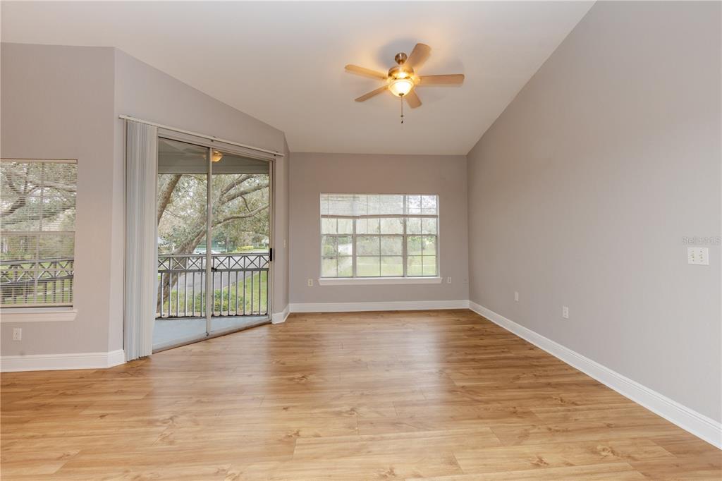 An empty room with light wood-look flooring, a ceiling fan, and a sliding glass door — 2302 MID TOWN TERRACE UNIT 1228, ORLANDO, FL